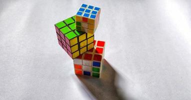 Jakarta, December 2022. Three rubik's cubes of different sizes and colors isolated on white background. Free space photo