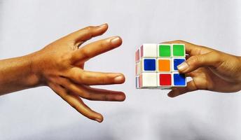 Jakarta, December 2022. An illustration concept of a human hand that will pick up a rubik's cube and play with it photo