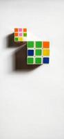 Jakarta, December 2022. Two rubik's cubes of different sizes and colors isolated on white background. Free space photo