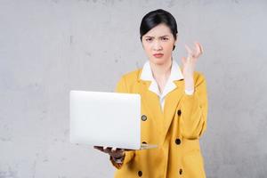 Photo of young Asian woman holding laptop