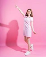 Full length photo of young Asian girl on pink background