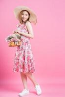 Photo of young Asian girl wearing flower dress on pink background