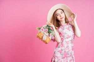 Photo of young Asian girl wearing flower dress on pink background