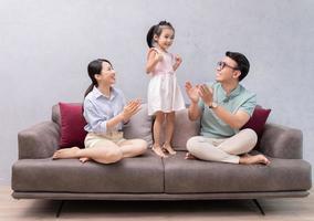 Young Asian family sitting on sofa photo