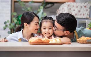 joven familia asiática en la cocina foto