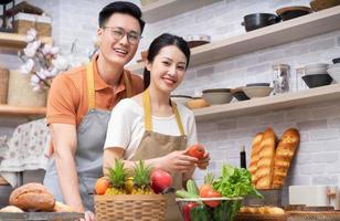 Image of young Asian couple cooking in the kitchen photo