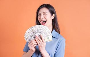 Young Asian business woman posing on orange background photo