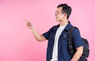 imagen de un joven estudiante universitario asiático de fondo rosa foto