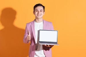 Portrait of young Asian man posing on background photo