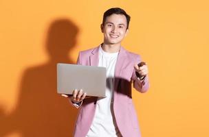 Portrait of young Asian man posing on background photo