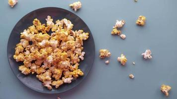 Popcorn in einer Schüssel auf blauem Hintergrund von oben nach unten video