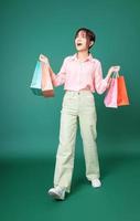 Image of young Asian girl holding shopping bag on background photo