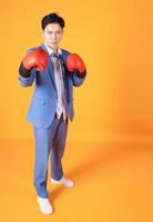 imagen de un joven empresario asiático enojado con guante de boxeo foto