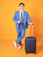 Image of young Asian business man holding suitcase on background photo