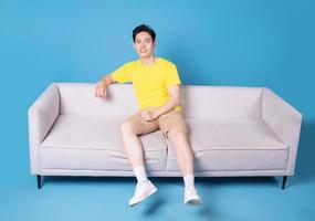 Image of young Asian man sitting on sofa photo