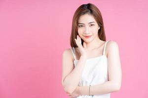 Image of young Asian woman posing on pink background photo