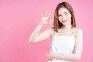 Image of young Asian woman posing on pink background photo