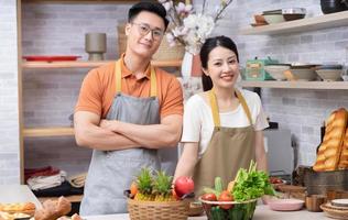 Image of young Asian couple cooking in the kitchen photo