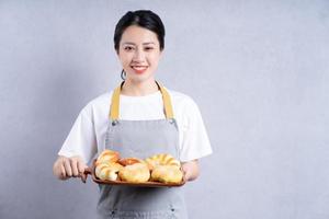 joven asiática sosteniendo pan en el fondo foto