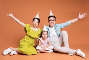 joven familia asiática posando en el fondo foto