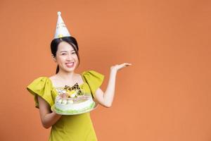 joven asiática sosteniendo pastel de cumpleaños foto