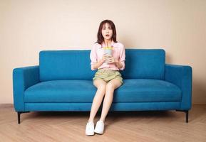 Image of young Asian woman sitting on sofa photo