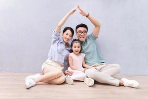 joven familia asiática sentada en el suelo foto