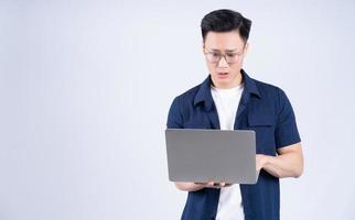 Young Asian man using laptop on white background photo