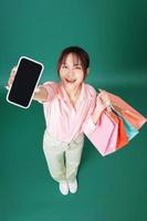 Image of young Asian girl holding shopping bag on background photo
