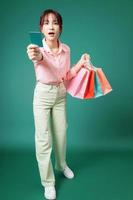 Image of young Asian girl holding shopping bag on background photo