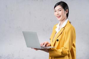 foto de una joven asiática sosteniendo una laptop