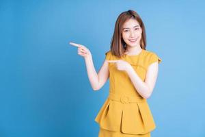 Portrait of young Asian woman posing on blue background photo