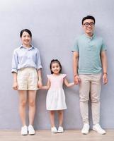 joven familia asiática de pie en el fondo foto