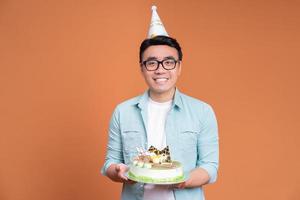 Young Asian man holding birthday cake photo