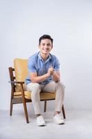 Image of young Asian man sitting on chair photo