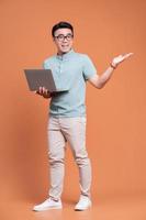 Full length image of young Asian man standing on backgound photo