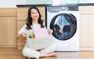 Image of Young Asian woman washing clothes photo