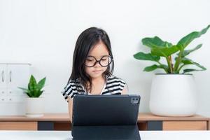 Asian child girl student wow excited on video call learning to studying online class or person learn from home school with tablet photo