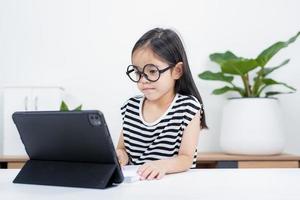 Asian child girl student wow excited on video call learning to studying online class or person learn from home school with tablet photo