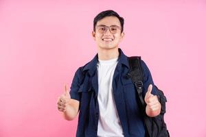 Image of young Asian college student on pink background photo