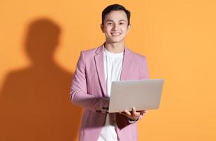 Portrait of young Asian man posing on background photo