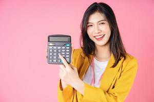 Image of young Asian businesswoman using calculator photo