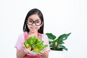 niños niña asia comiendo verduras foto