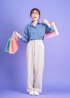 Image of young Asian businesswoman holding shopping bag photo