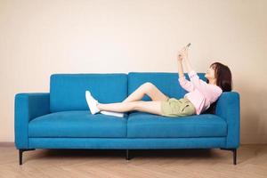 Image of young Asian woman sitting on sofa photo