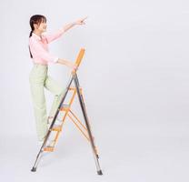 Image of young Asian woman clamb up to the ladder photo