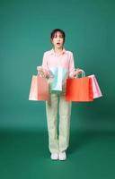 Image of young Asian girl holding shopping bag on background photo