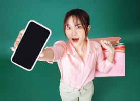 Image of young Asian girl holding shopping bag on background photo