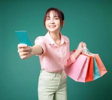 Image of young Asian girl holding shopping bag on background photo