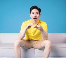 Image of young Asian man sitting on sofa photo